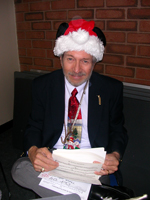 A picture of Ron Pettus, wearing a Santa hay, scrolling through music.
